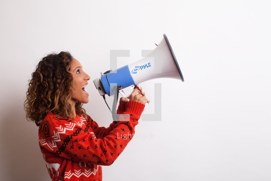 woman in an ugly Christmas sweater yelling into a megaphone 
