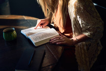 a woman reading a Bible at a coffee shop