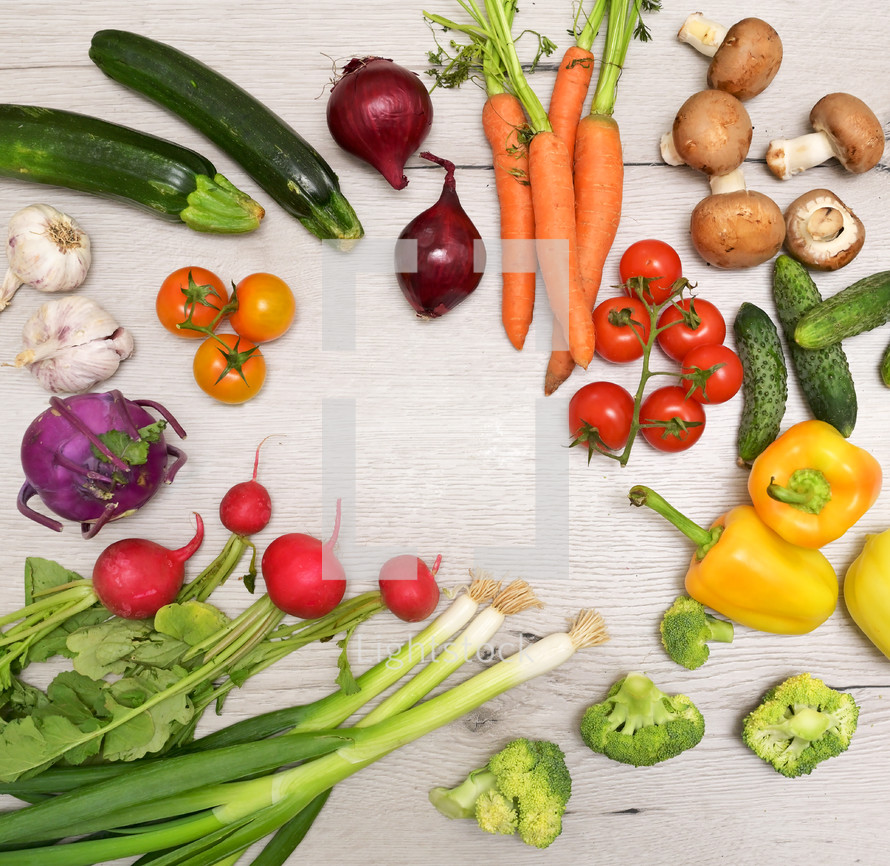 Different fresh vegetables on wooden table in studio