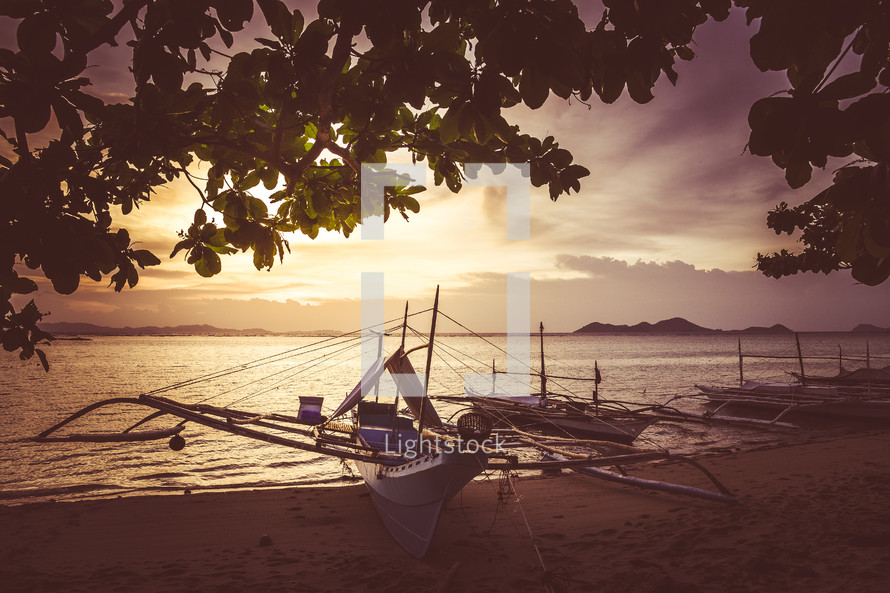 boats beached on a shore at sunrise 