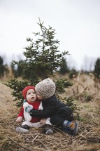 brothers hugging in a Christmas tree lot 
