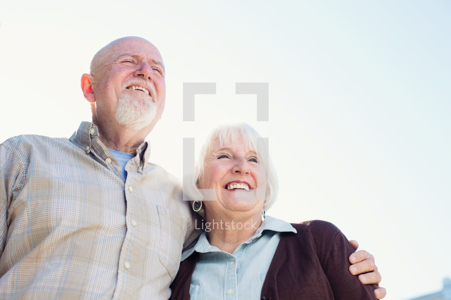 a mature couple standing and laughing together. 