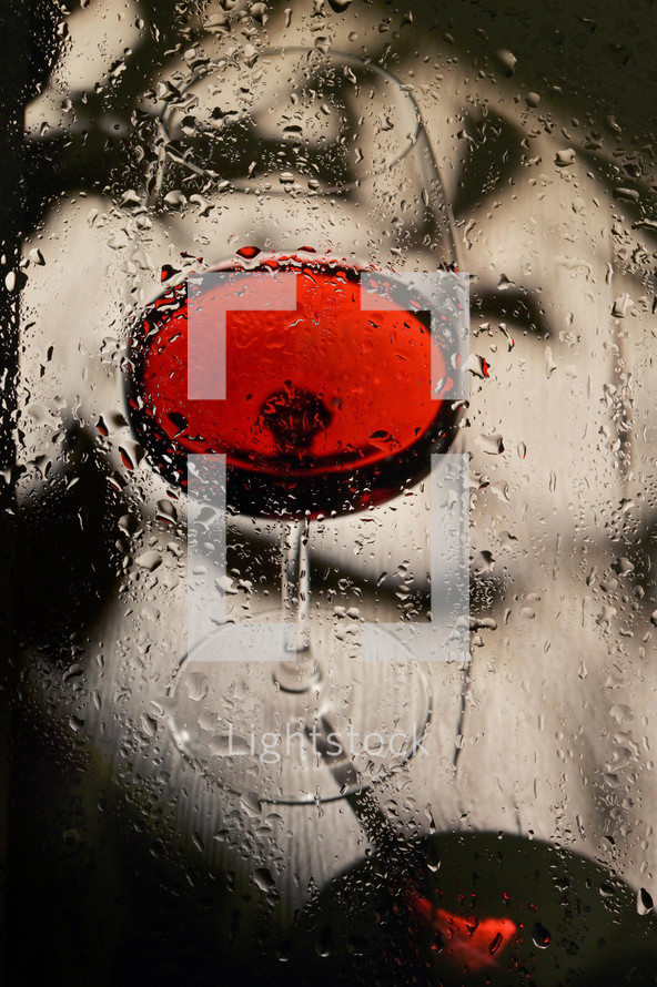 Abstract Glass Of Dry Red Wine Through Rainy Window