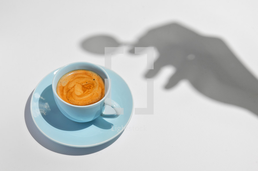 Abstract Cup Of Coffee with a Spoon and Hand Silhouette