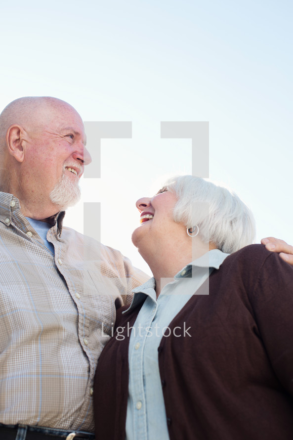 an elderly couple standing together 