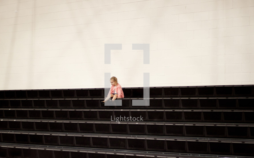 toddler girl sitting on steps outdoors 