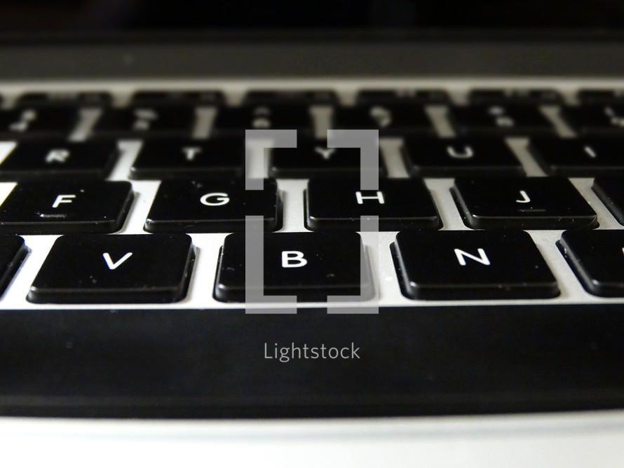 Close-up of space bar and letter keys on silver keyboard