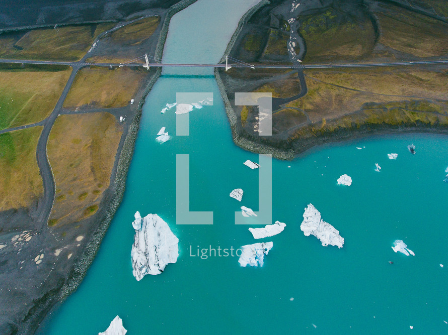 aerial view above a shoreline and icebergs 
