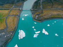 aerial view above a shoreline and icebergs 