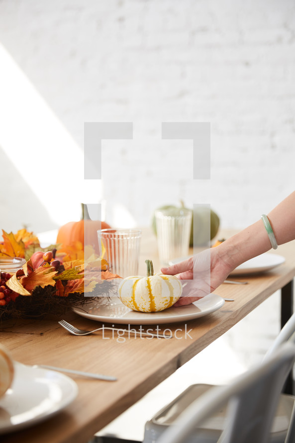 woman setting a table for a fall dinner party 