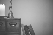 An office desk with a bell and books. 