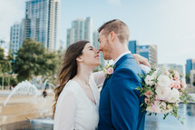 bride and groom in front of a city scene 