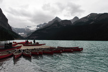 canoes tied to a dock on a mountain lake 