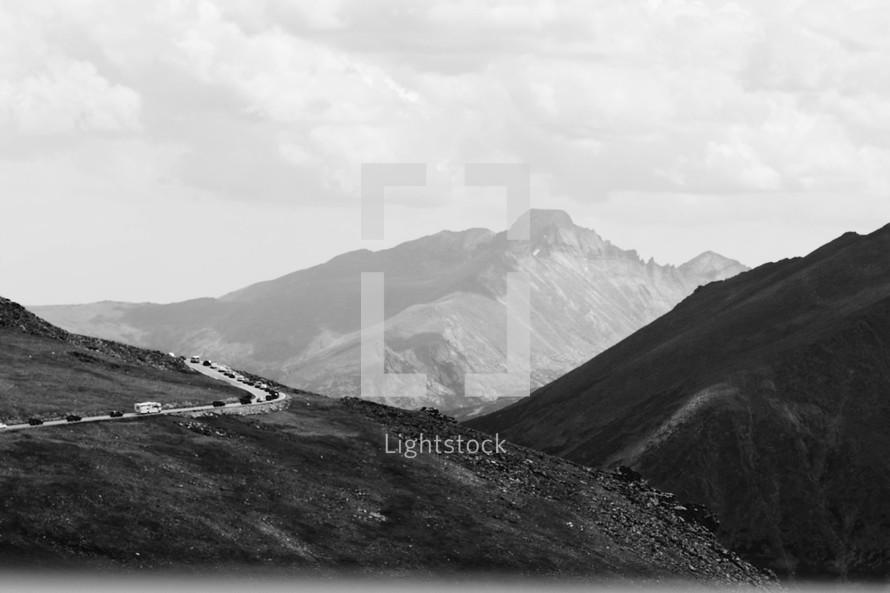 Vehicles on a highway through mountains.