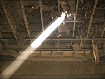 ray of light shining through a hole in the roof of an abandoned warehouse 