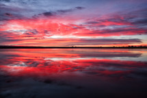 reflection of a pink and purple sky over water 