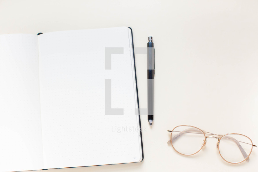notebook, pen, and reading glasses 