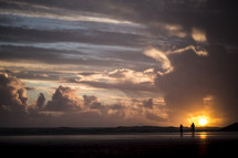silhouettes of a couple on a beach at sunset 