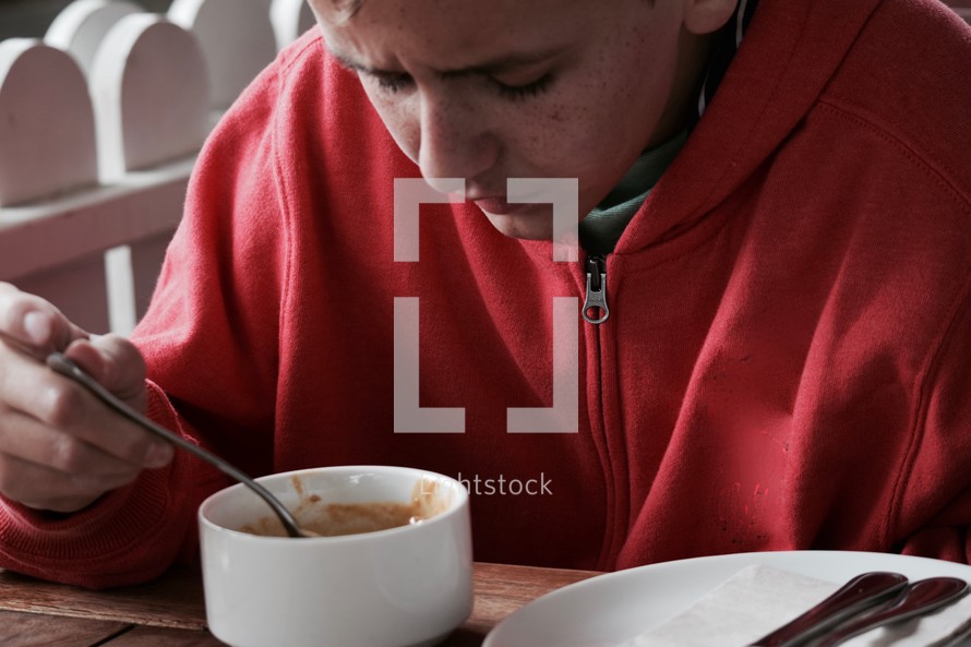 a boy eating soup 