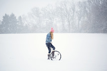 a woman with a unicycle in the snow 