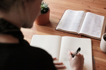 a woman reading a Bible and journaling 