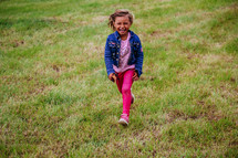 a young girl running in grass 