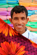Bangladeshi man folding fabric in the market 