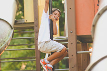 child sliding down a pole at a playground 