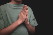 a boy with praying hands 