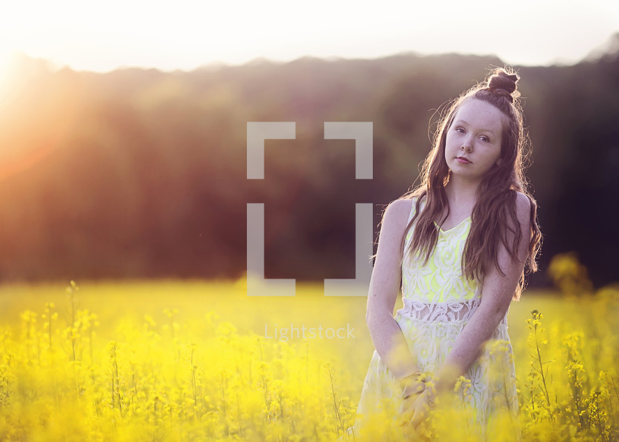 teen girl standing in a field 