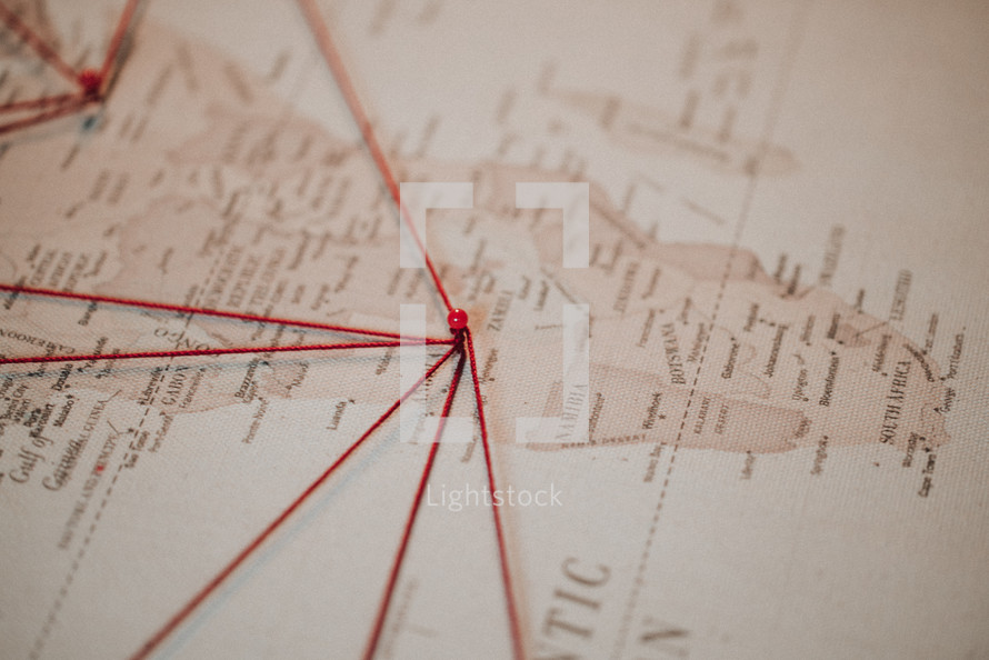push-pins and string on a world map 