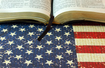 An open Bible on an American flag.