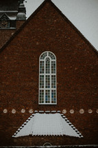 snow on a brick church roof 