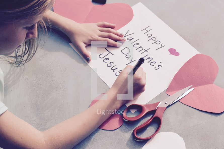 A little girl drawing a Valentine's day card for Jesus 