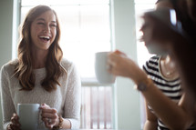 women drinking coffee, talking, and laughing at a Bible study 