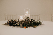 candles and greenery on a table at a wedding reception 