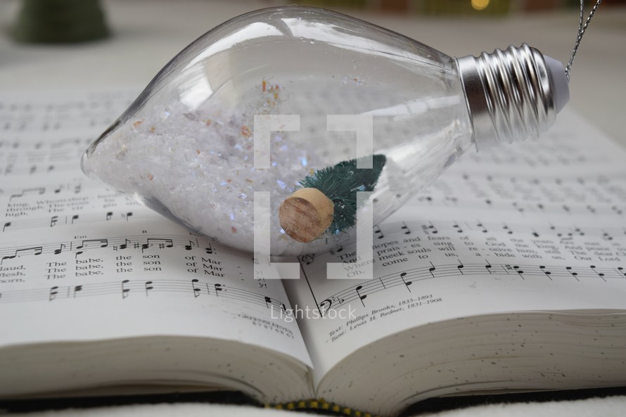 Christmas bulb ornament with snow on a hymnal 