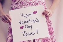 A little girl holding a Happy Valentine's Day Jesus sign 