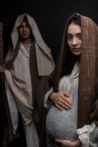 pregnant Mary holding her belly and Joseph 