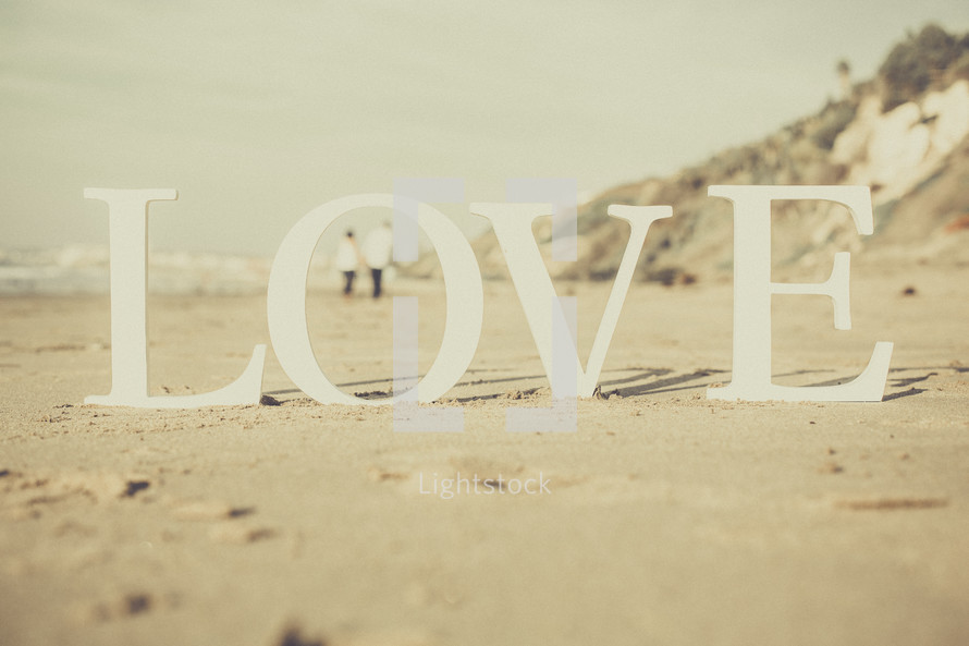 couple on a beach and the word love