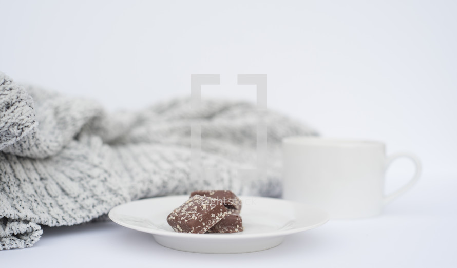 sweater blanket and cookies on a plate 