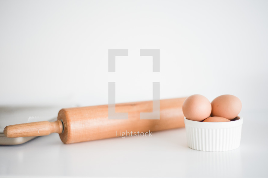 rolling pin and eggs in a bowl 