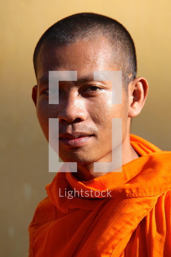 head shot of a Buddhist monk in an orange robe 