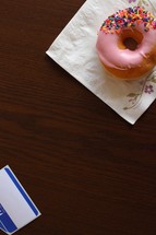 a donut on a napkin and blank name tag 