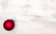 single red ornament on marble 