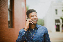 a smiling man talking on a cellphone 