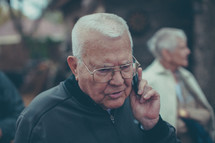 an elderly man talking on a cellphone 