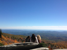 friends sitting on a mountaintop in fall 