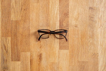 reading glasses on a wood background 