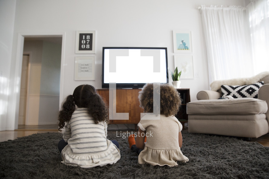 kids watching television in a living room.